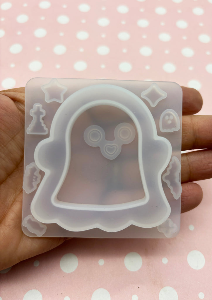 a hand holding a plastic mold with a ghost on it