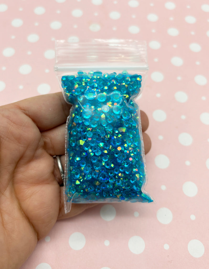 a hand holding a bag of blue glitter
