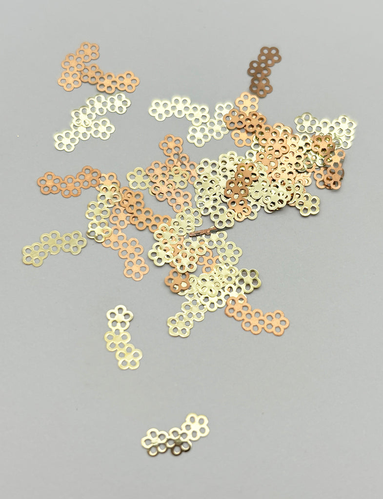 a pile of gold and silver confetti on a gray surface