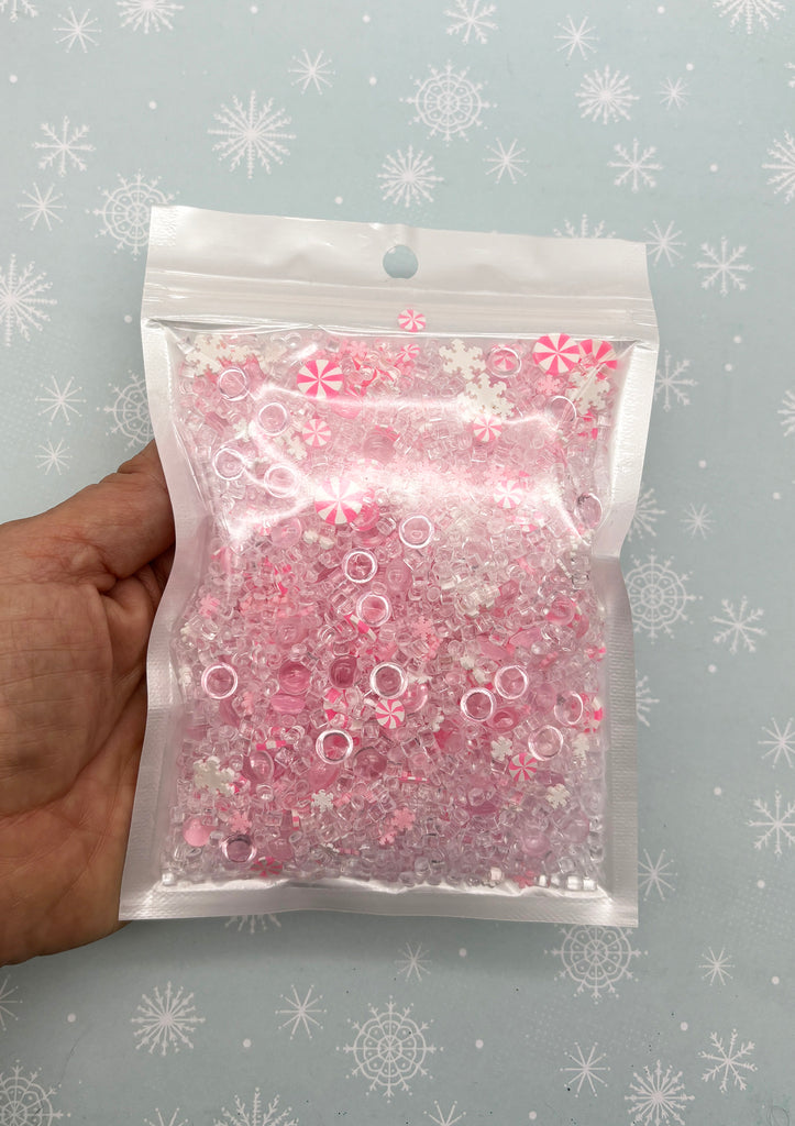 a bag filled with lots of pink and white beads