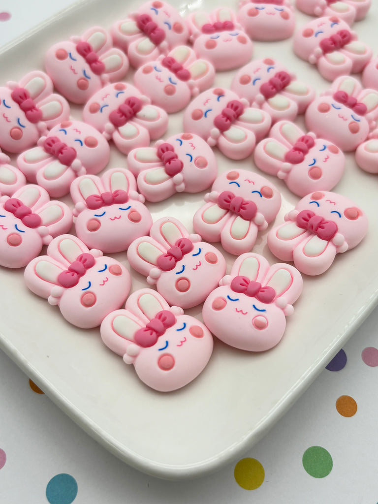 a white plate topped with lots of pink teddy bears