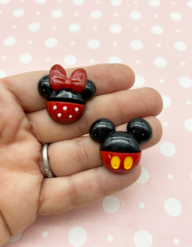 a hand holding two mickey mouse rings