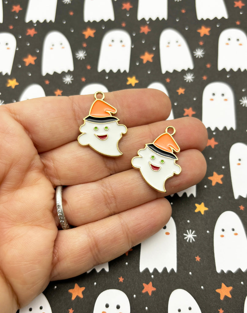 a hand holding a pair of halloween charms