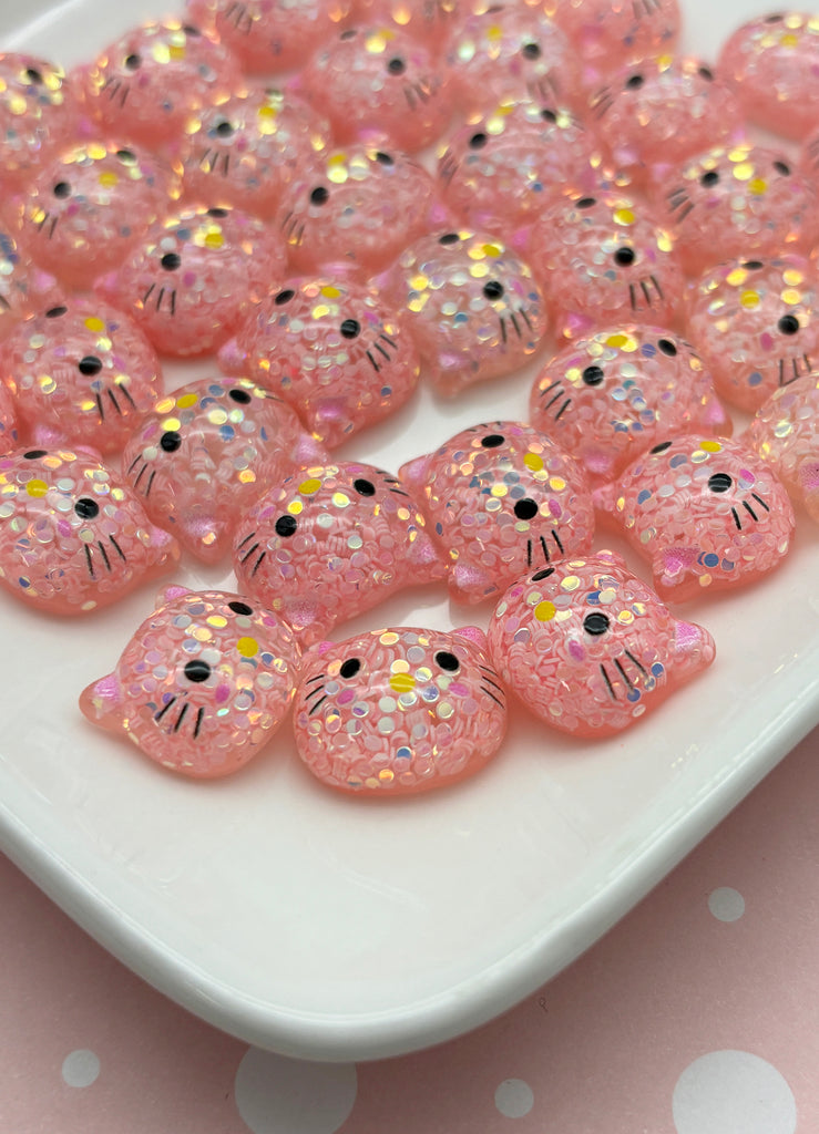 a white plate topped with lots of pink kitty beads