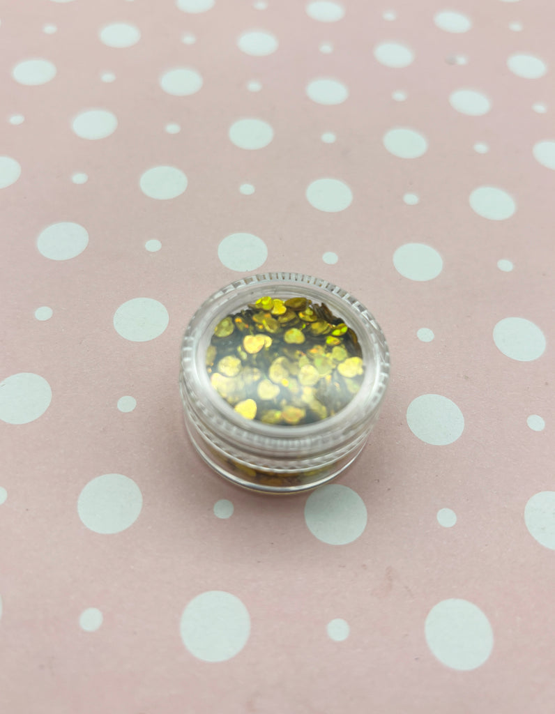 a small jar of glitter sitting on top of a polka dot tablecloth