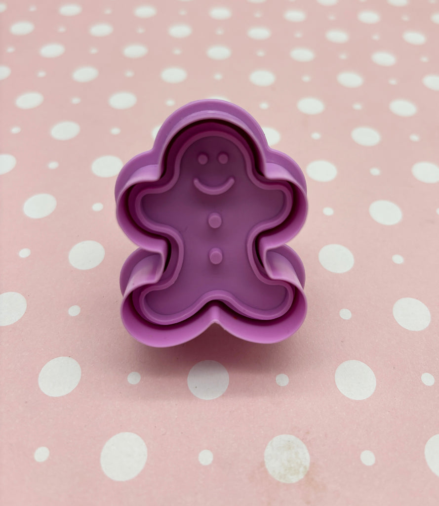 a cookie cutter shaped like a ginger on a polka dot tablecloth