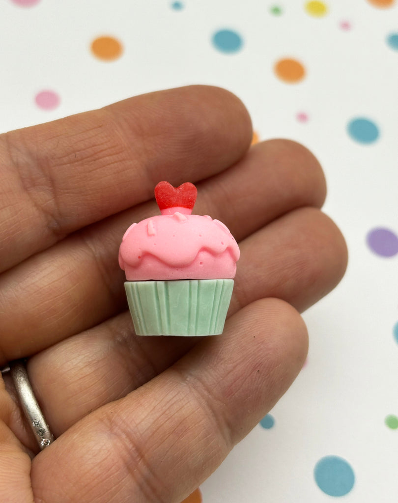 a tiny pink cupcake with a heart on top of it