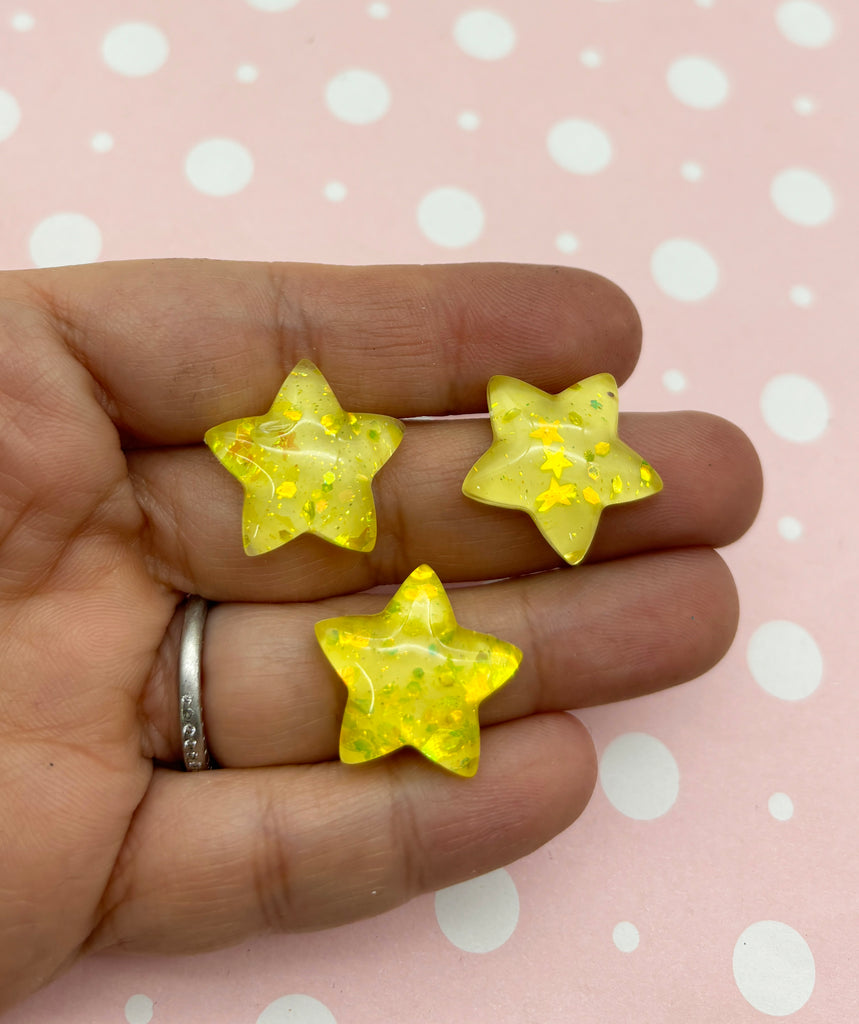 a person holding three yellow stars in their hand