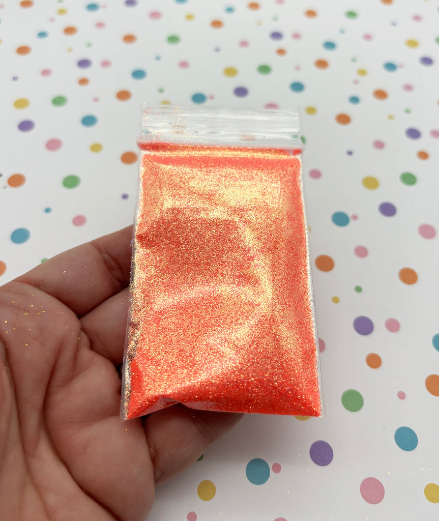 a hand holding a small bag of glitter