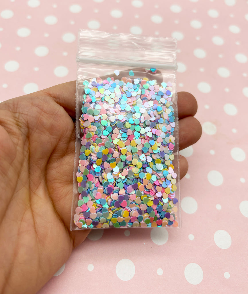 a hand holding a bag of colorful sprinkles