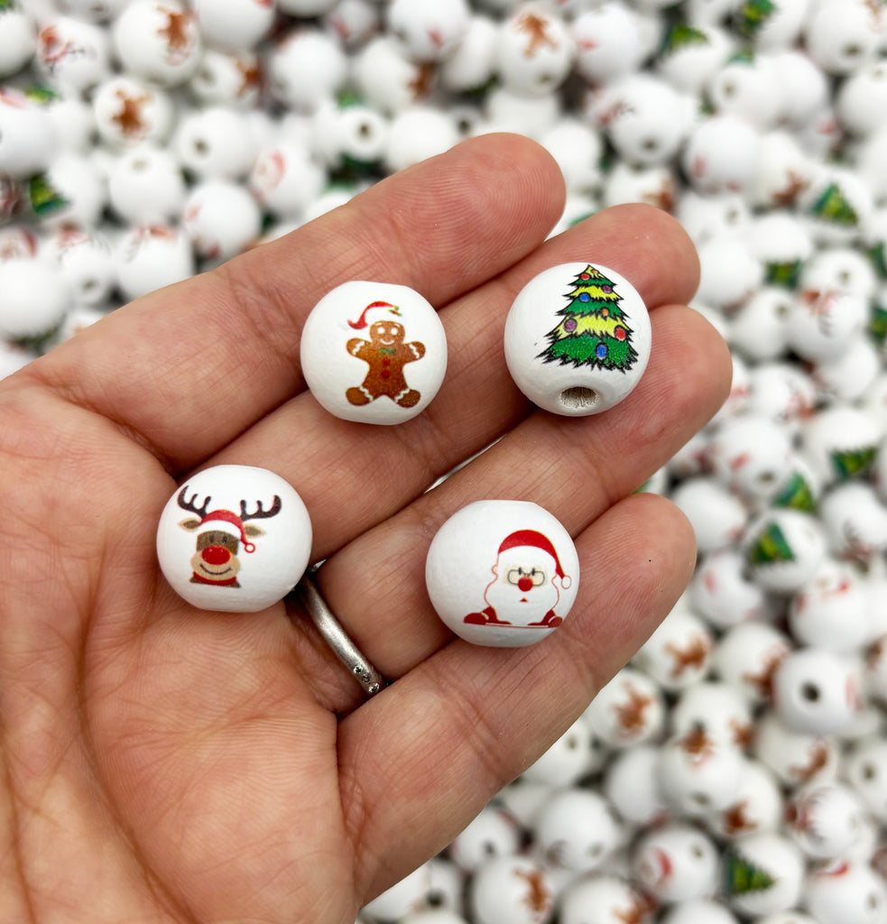 a hand holding three christmas themed buttons