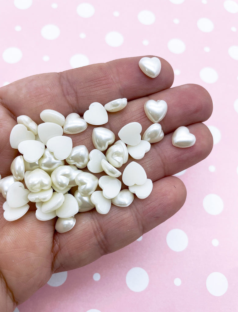 a hand holding a handful of white pearls