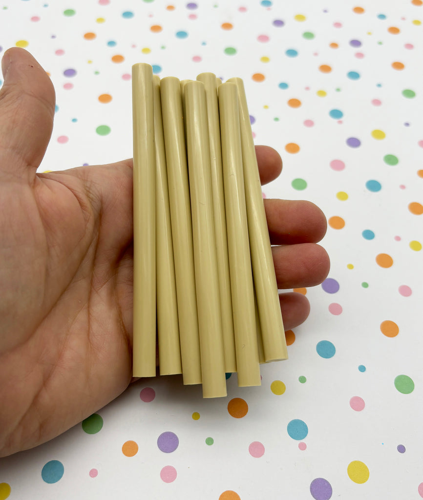 a hand holding a bunch of yellow sticks