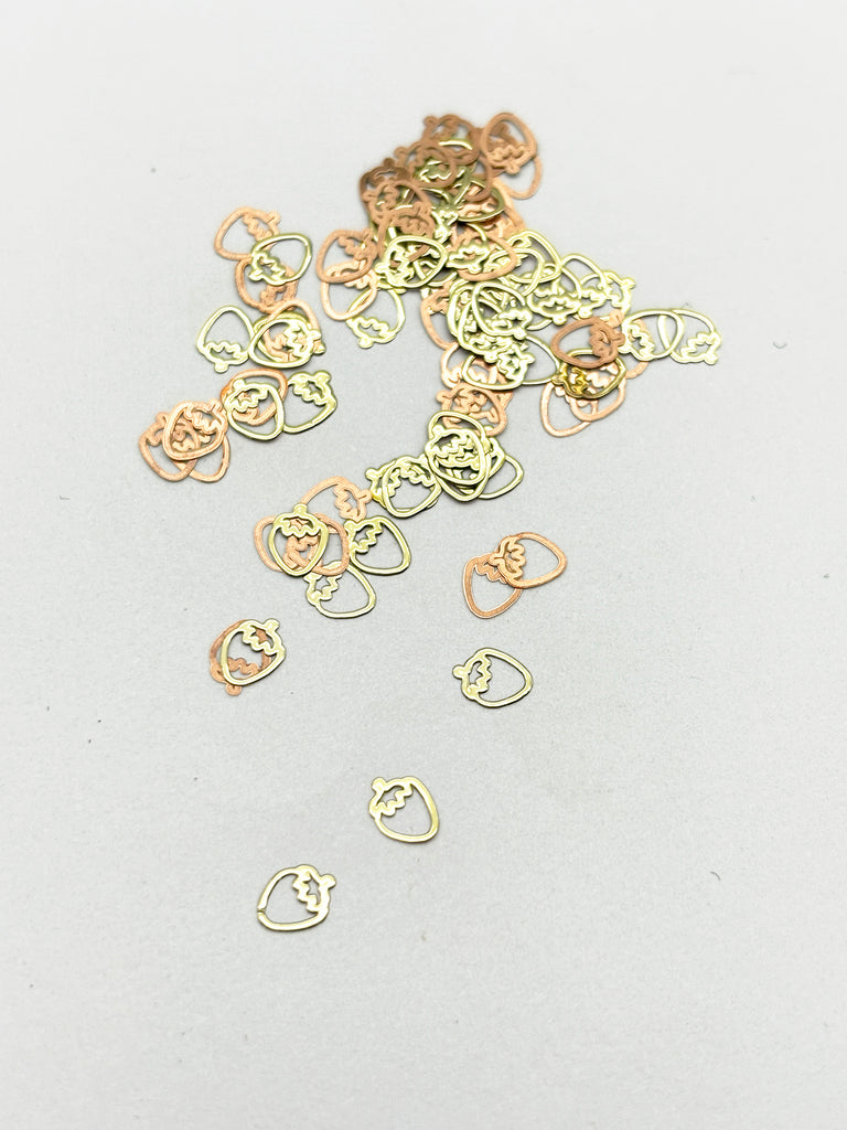 a pile of gold colored metal rings on a white surface