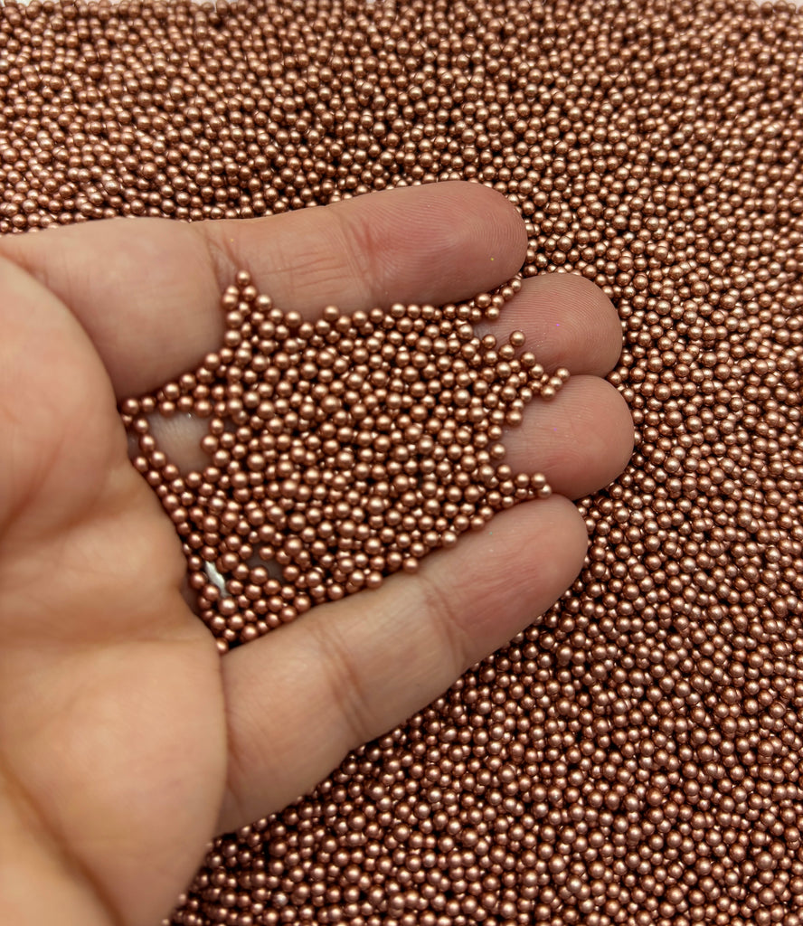 a hand is pointing at a beaded surface