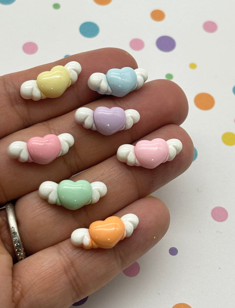 a person's hand holding a small assortment of candy hearts
