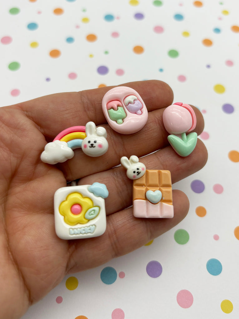 a hand holding a small assortment of small toy animals