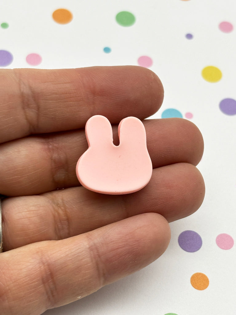 a person holding a small pink bunny ear pin