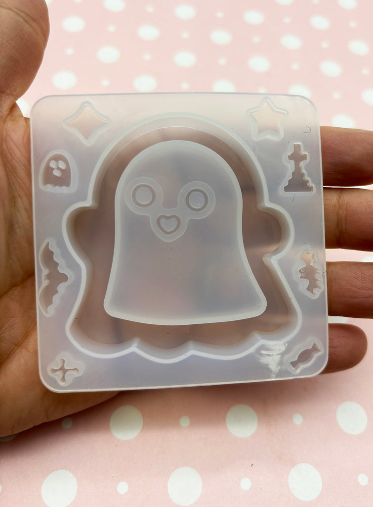 a hand holding a plastic mold with a ghost on it