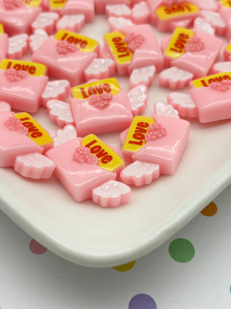 a white plate topped with pink and yellow candies