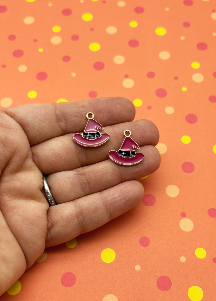 a hand holding a pair of pink earrings