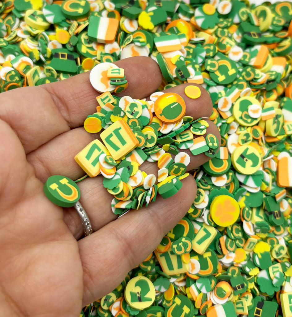 a hand holding a pile of green and yellow buttons