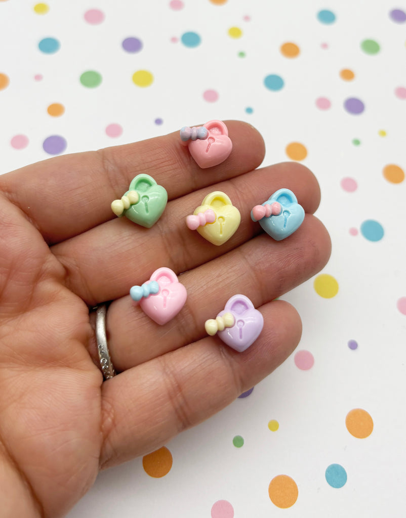 a person's hand is holding a small set of tiny bowknots