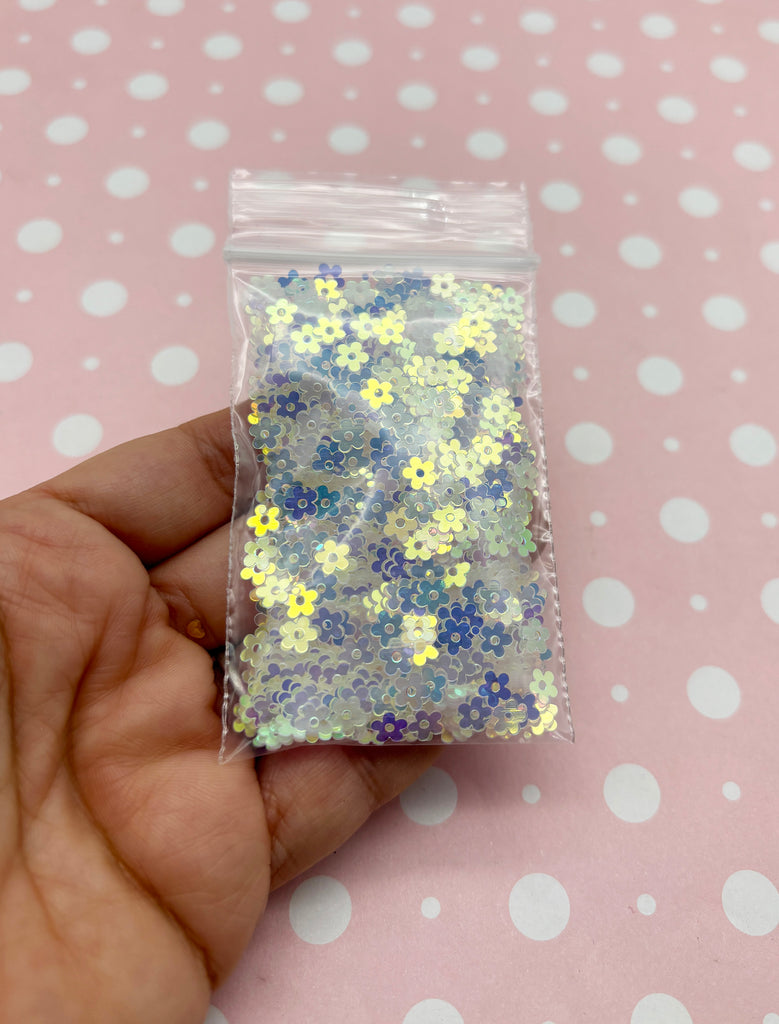 a hand holding a bag of yellow and blue confetti