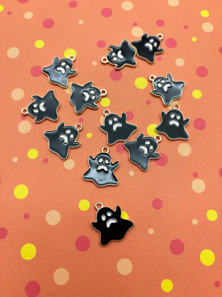 a group of black and white ghost charms sitting on top of a table