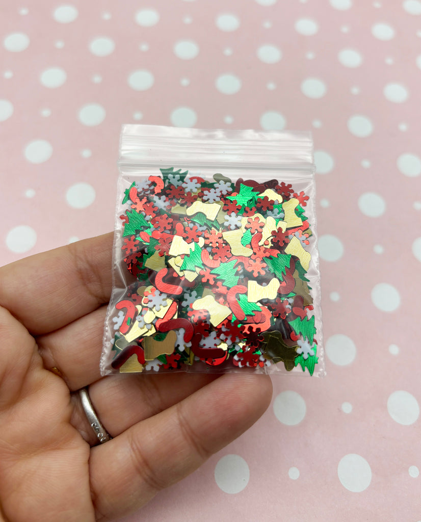 a hand holding a bag of christmas confetti