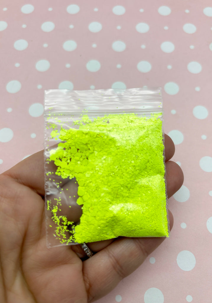 a hand holding a bag of yellow powder