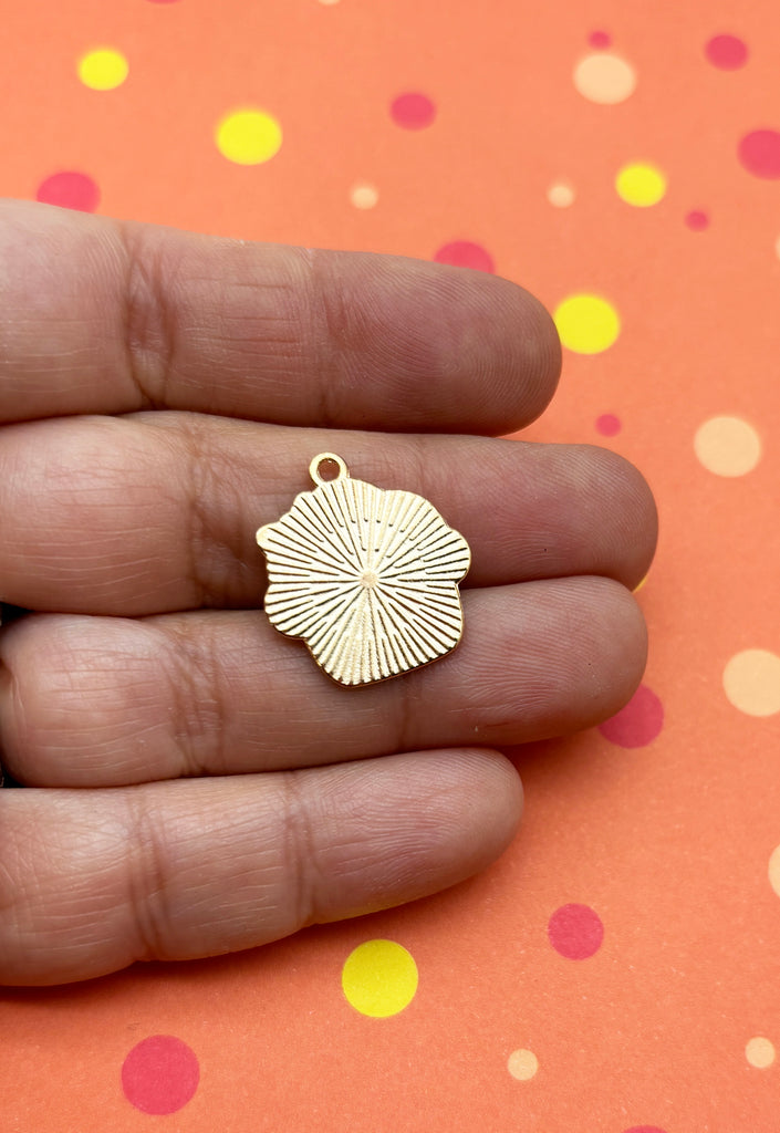 a person is holding a small gold pendant