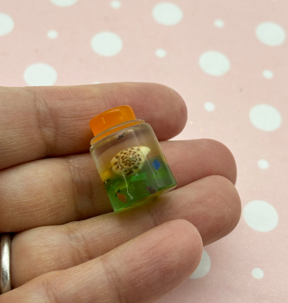 a person is holding a tiny pill bottle