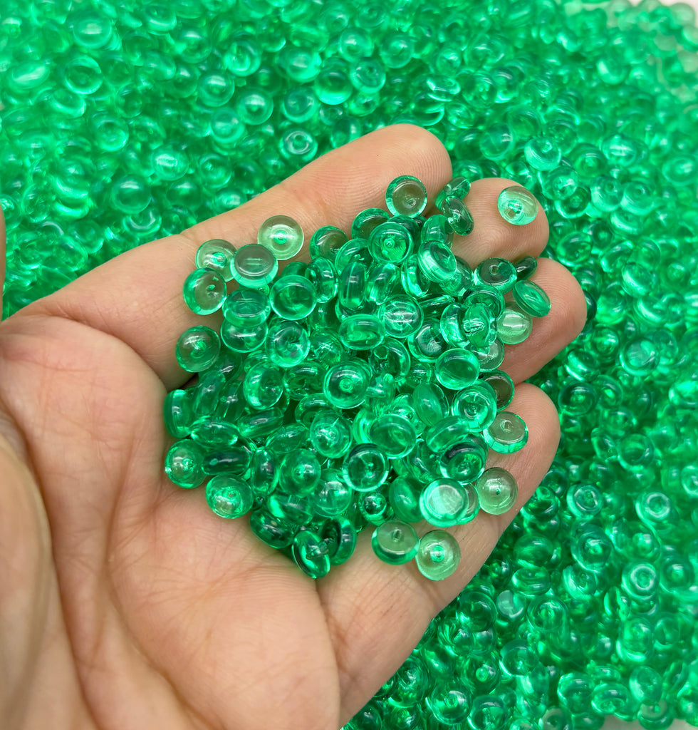 a hand holding a bunch of green beads