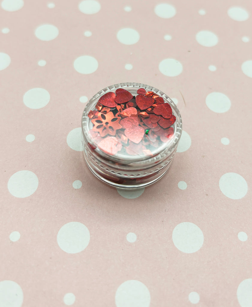 a glass jar filled with lots of red and pink confetti