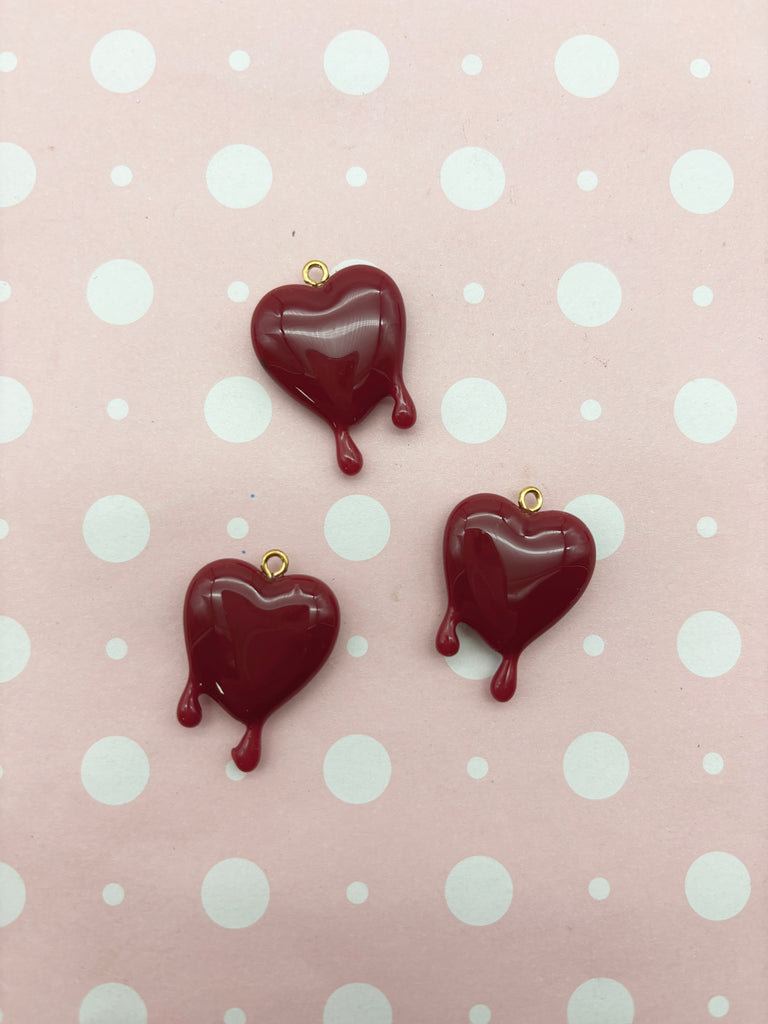 three heart shaped chocolates sitting on top of a table