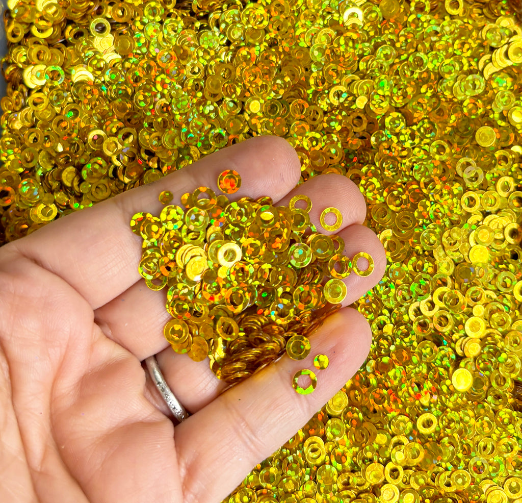a hand holding a bunch of yellow sequins