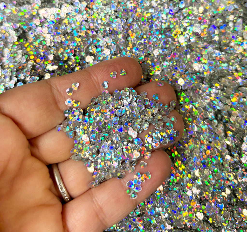 a hand holding a handful of glitter in it's palm