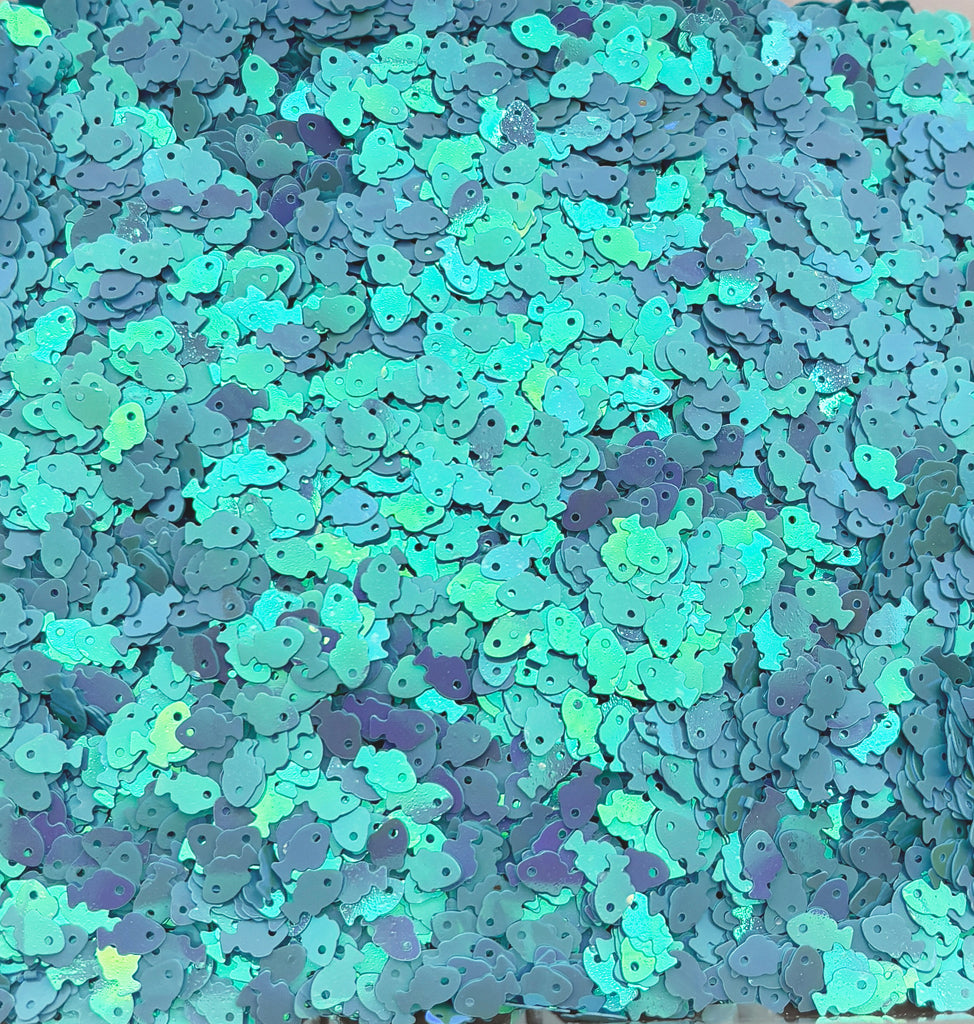 a pile of blue and green confetti sitting on top of a table