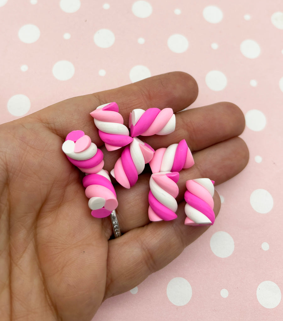 a hand holding a bunch of pink and white candy