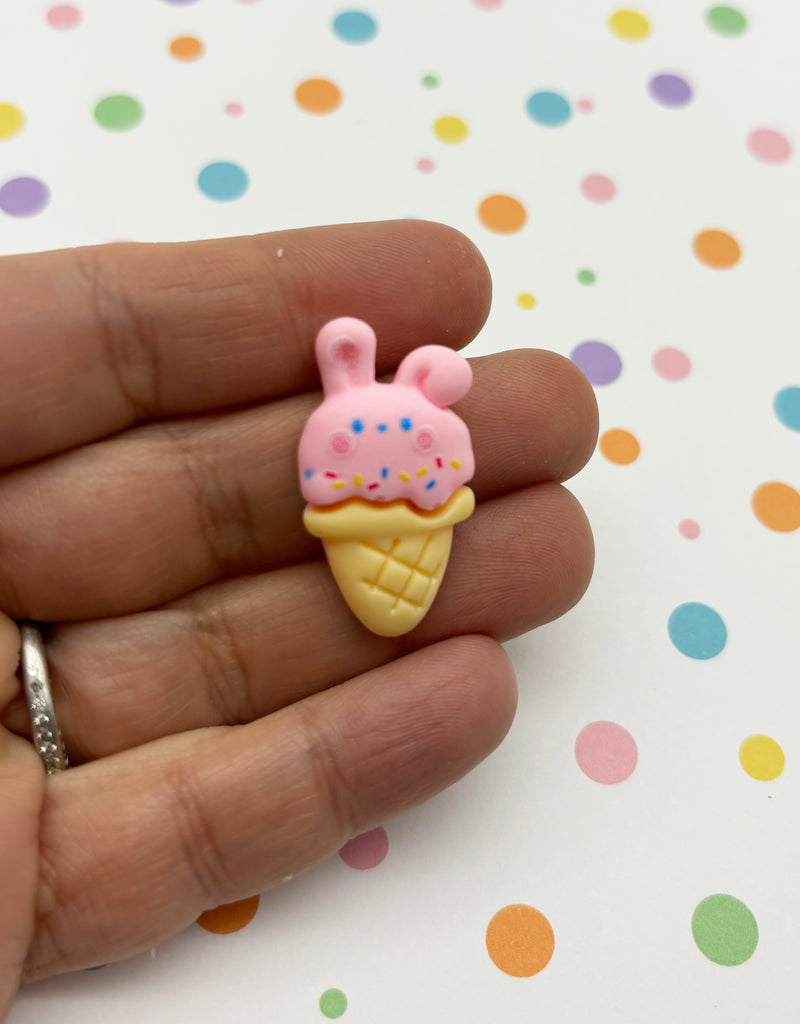 a hand holding a small toy ice cream cone