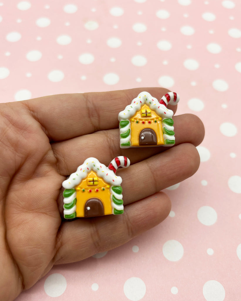 a hand holding two small gingerbread houses