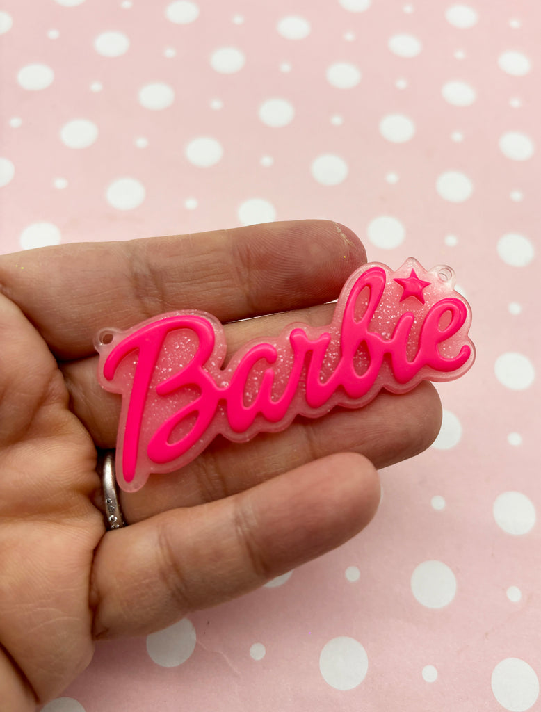 a person is holding a pink barbie hair clip