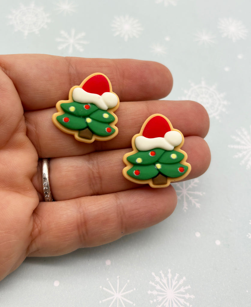 a hand holding a pair of christmas themed cookies