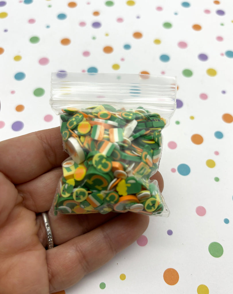 a hand holding a bag of green and yellow confetti
