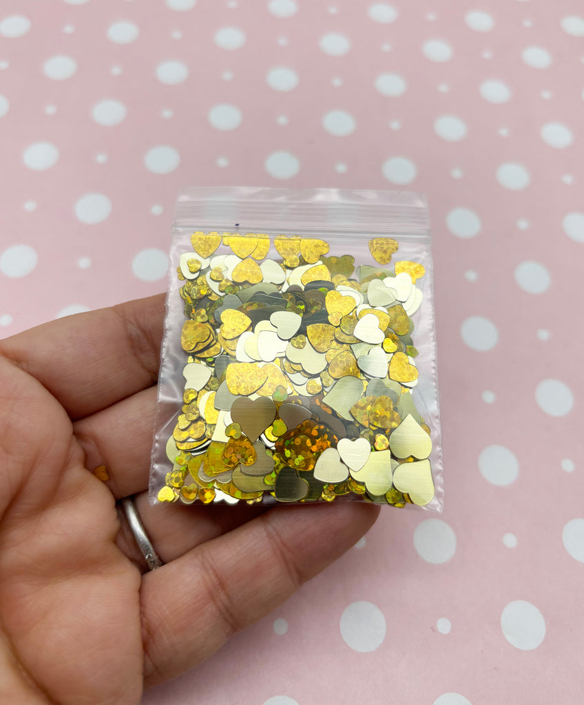 a hand holding a bag of gold and silver confetti