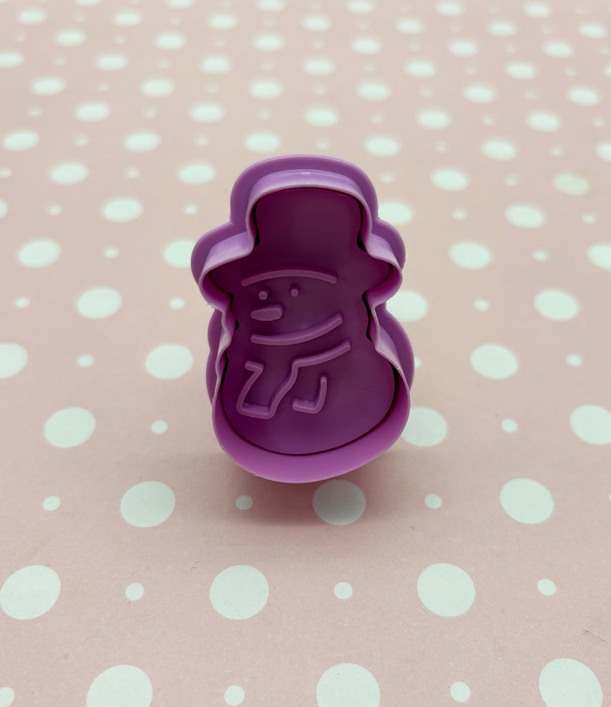 a purple cookie cutter sitting on top of a polka dot table