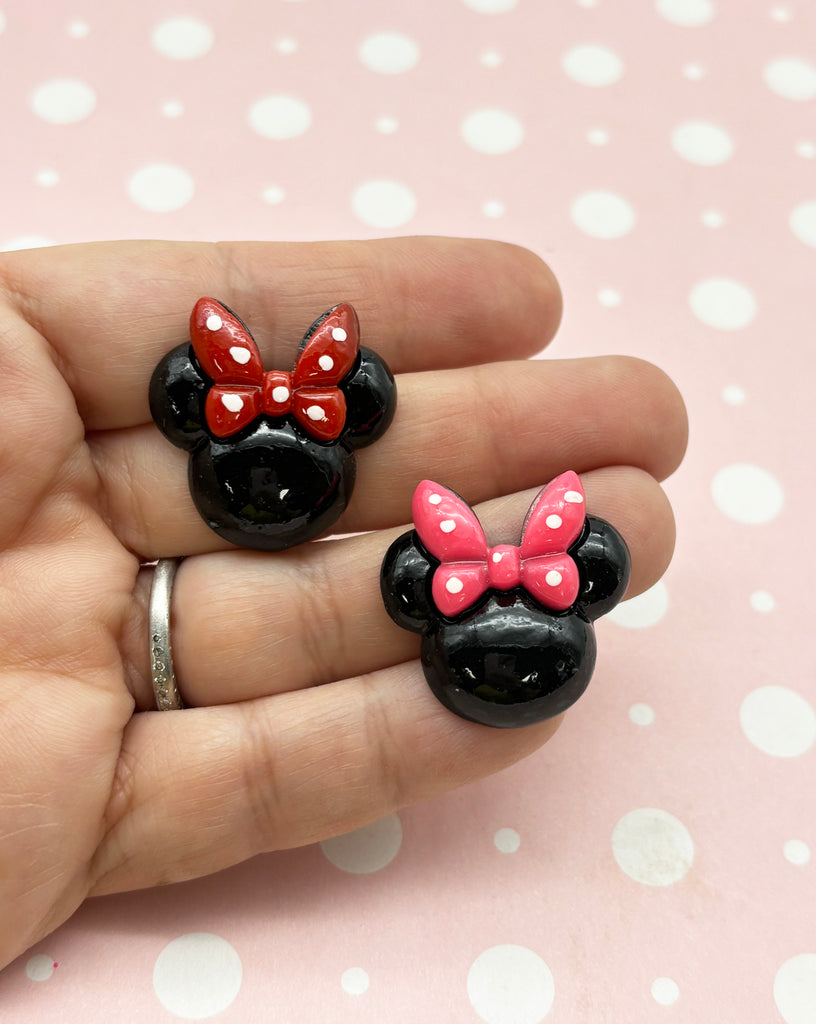 a person holding two minnie mouse rings in their hand