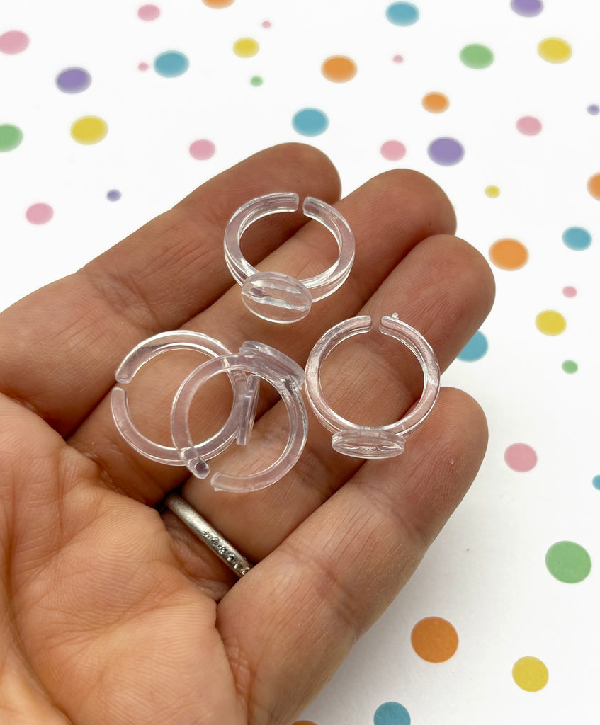 a hand holding three clear plastic rings