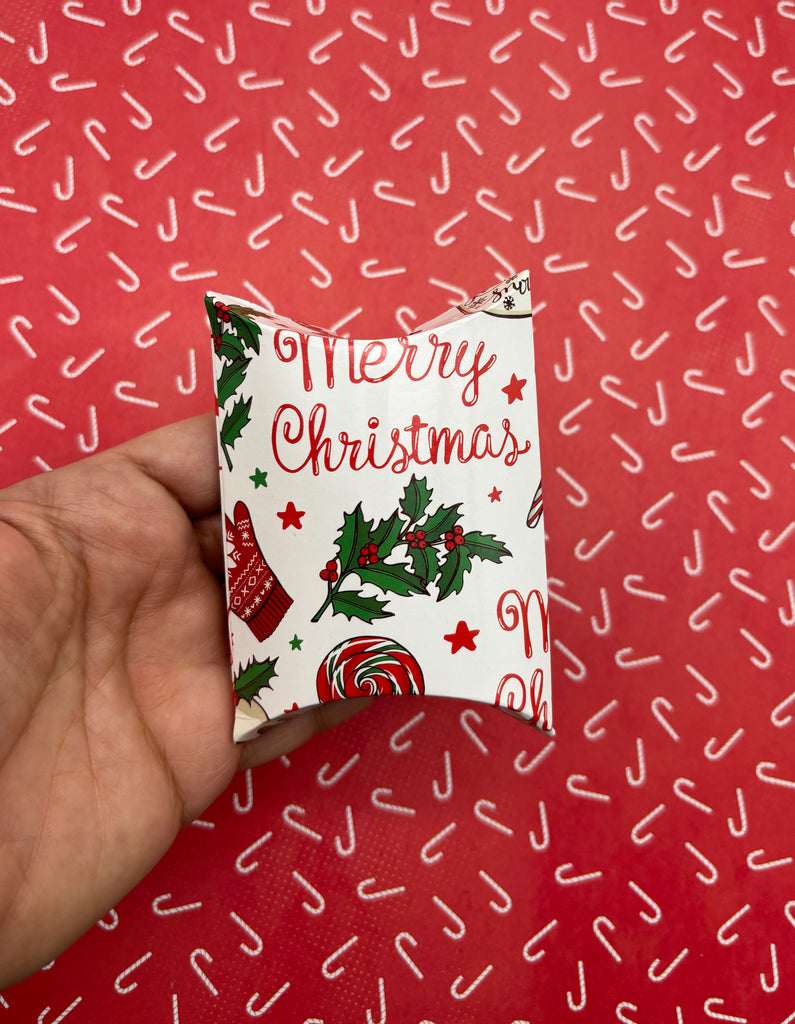 a hand holding a christmas card on a red background